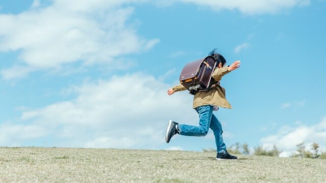 公園でランドセルを背負って走る男の子