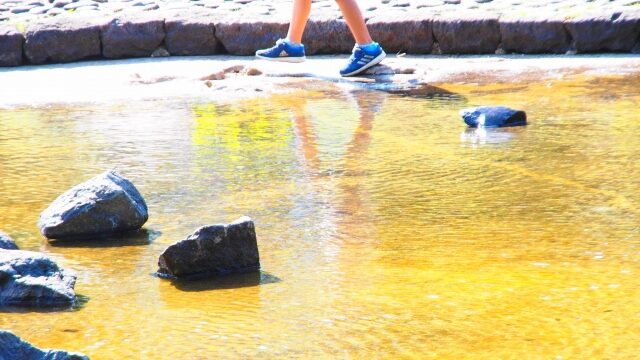 水たまりで遊ぶ子供